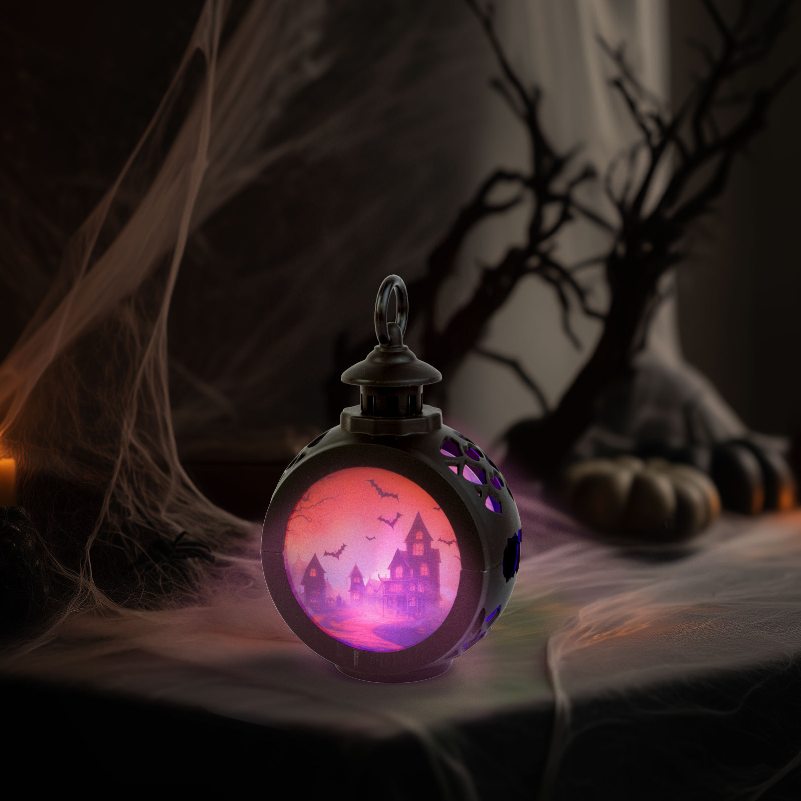 Egy Halloween-lámpás kísérteties jelenettel. Kísértetház, denevérek, lila-narancssárga ragyogás látható rajta. Pókháló a háttérben.