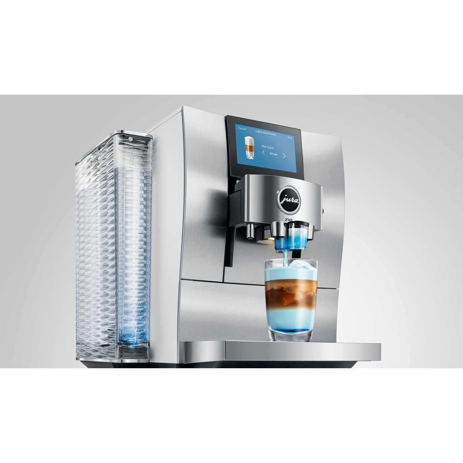 A Jura coffee machine making latte macchiato. A glass with ice, blue liquid, and layers of coffee sits below the spout.