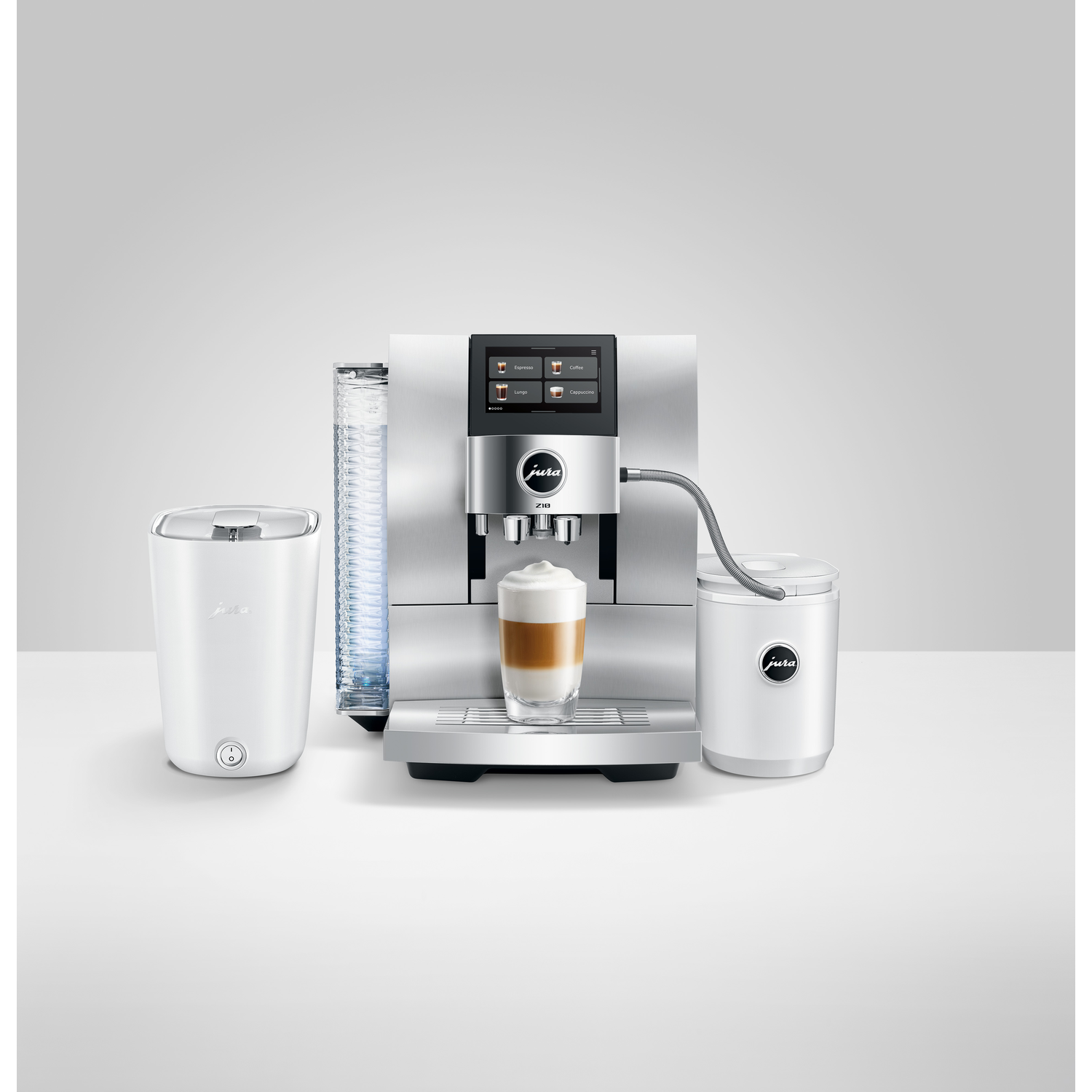 A coffee machine with a glass of latte, a milk container, a water container and a cup. All are white.