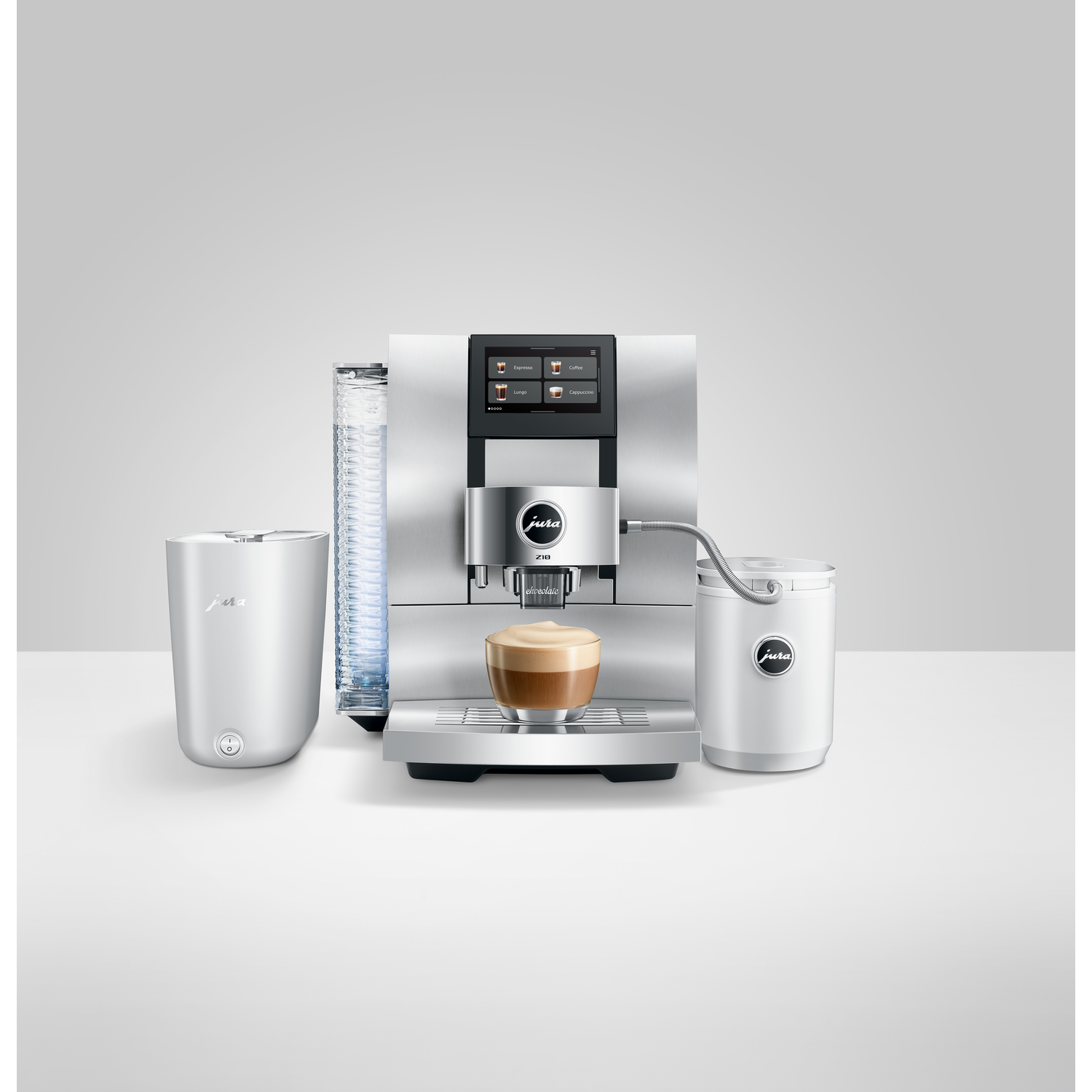 A silver Jura coffee machine with a coffee cup in front. There are white accessories and a water container on each side.