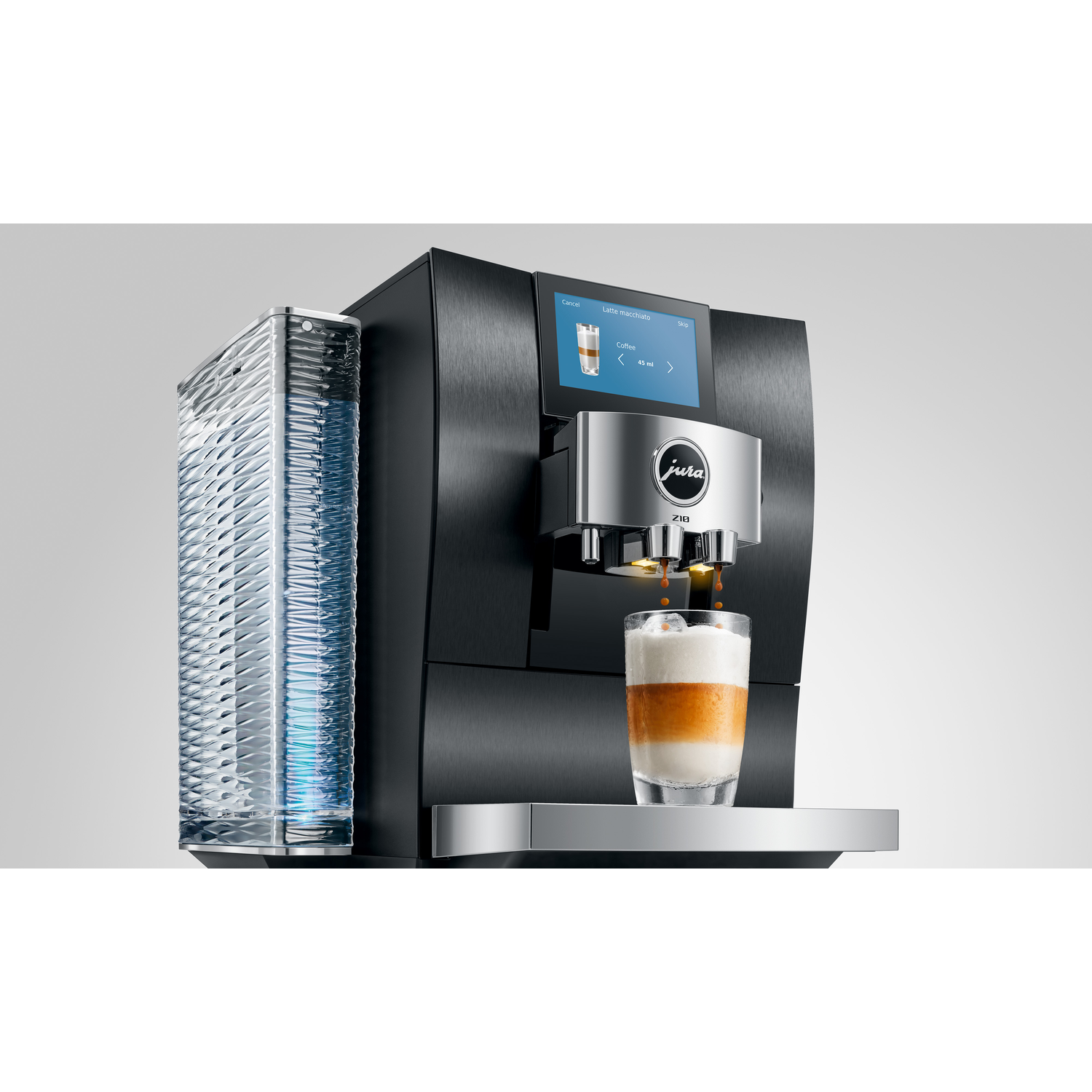 A black Jura coffee machine dispensing coffee into a glass of layered latte macchiato. A water tank is on the left.