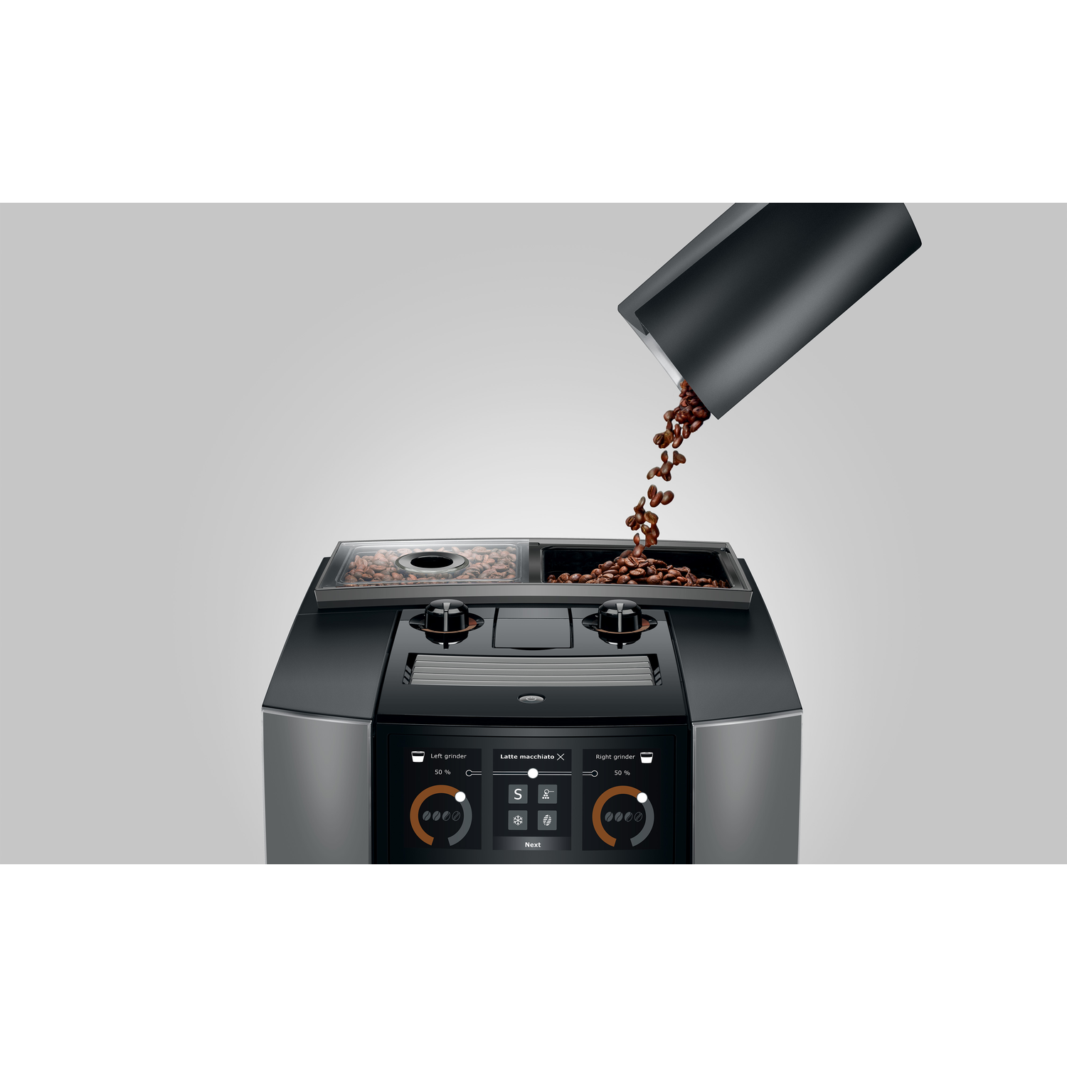 Coffee beans pouring into a coffee machine. The machine is black and silver with a digital display. 