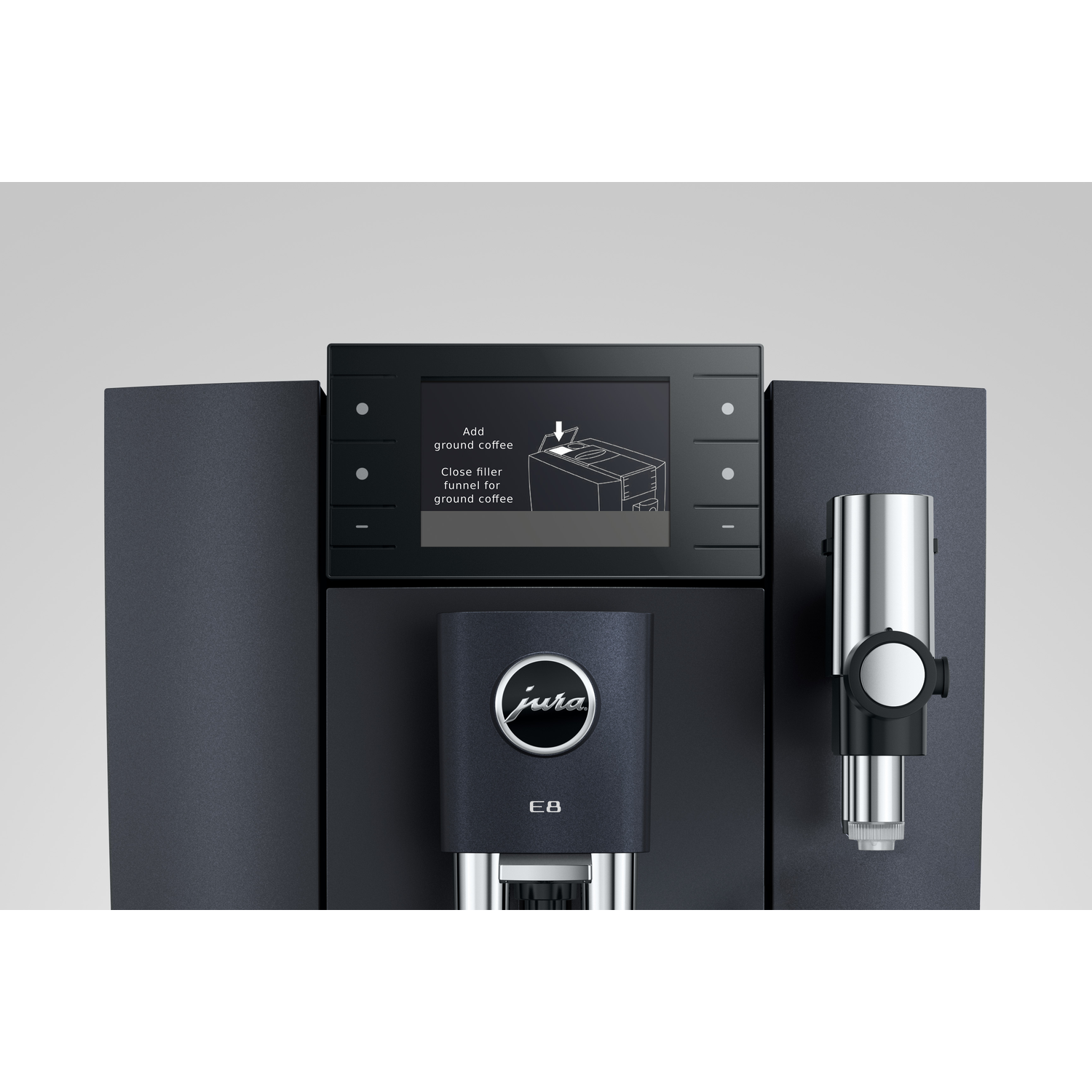 A black Jura E8 coffee machine. The screen shows instructions for adding ground coffee. A metallic spout and the Jura logo are visible.