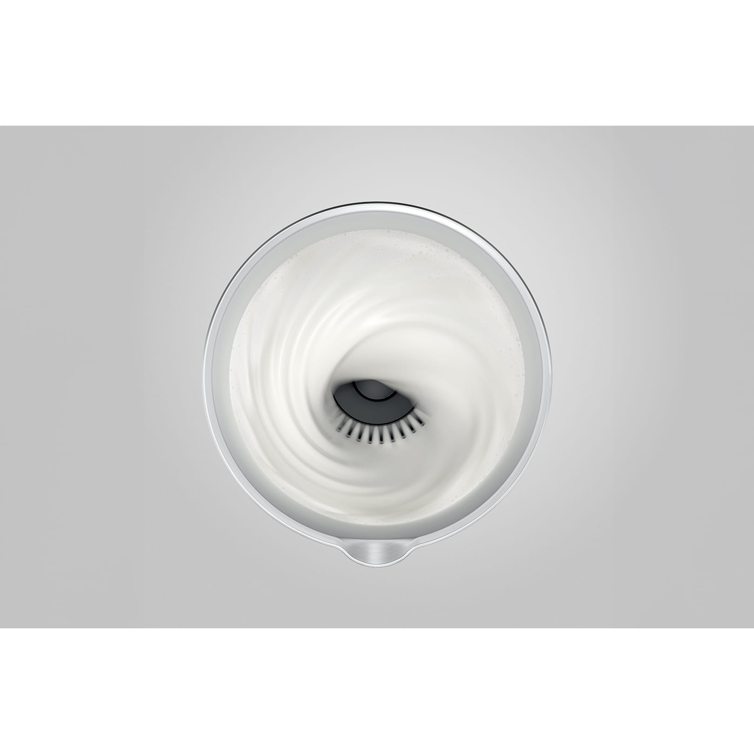 Top-down view of a frothing device with white liquid swirling inside. Gray background. The device is metallic and has a spout.