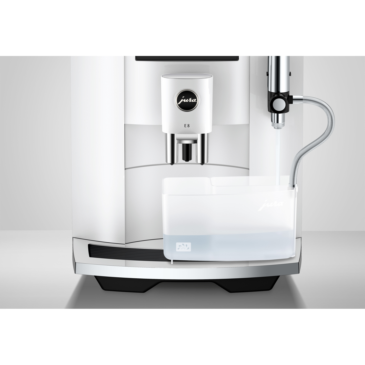 A white Jura E8 coffee machine. A transparent water container is in front. A silver hose dispenses water.