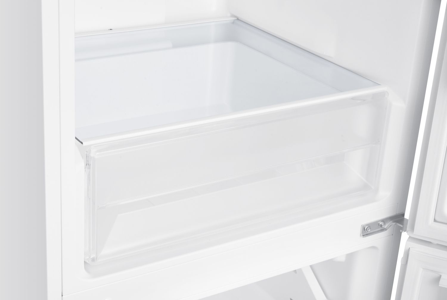 Interieur van een open koelkast. Een doorzichtige plastic lade is zichtbaar, samen met witte binnenwanden en een scharnier aan de rechterkant.