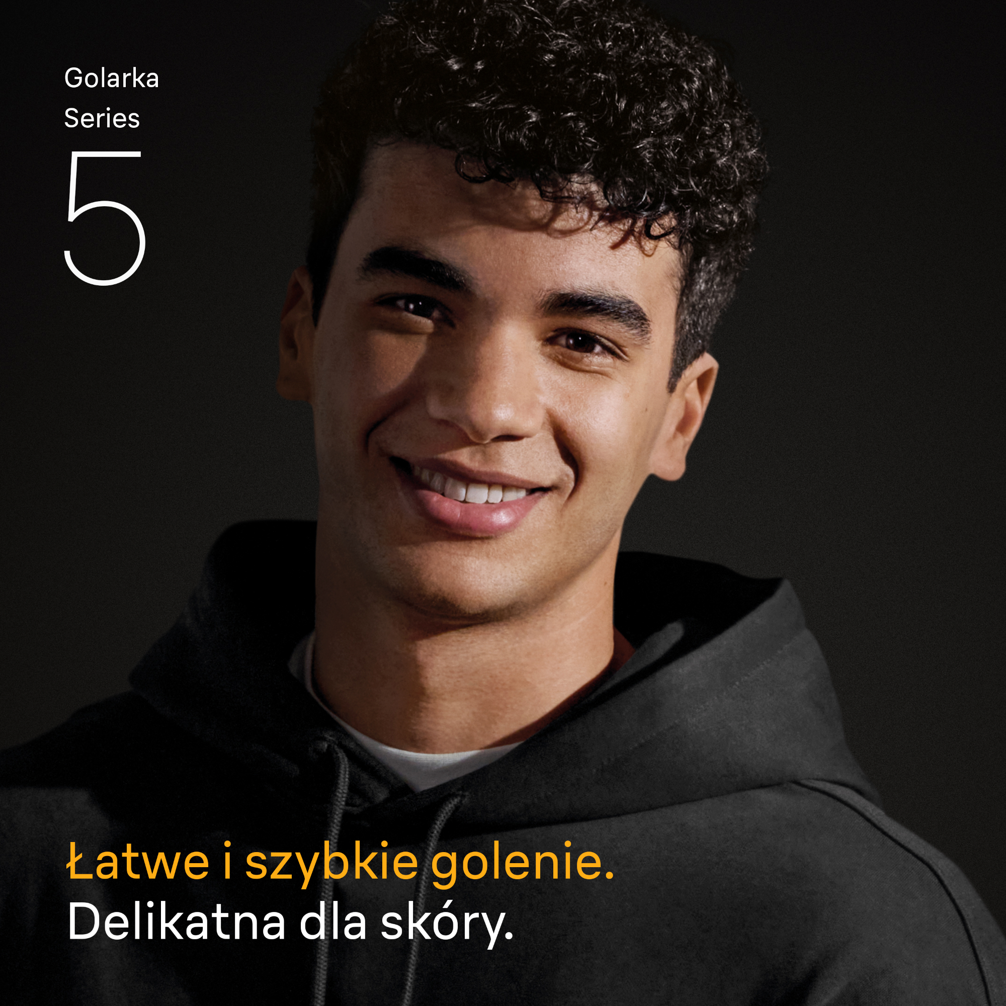 Uśmiechnięty mężczyzna w czarnej bluzie z kapturem. Tekst: 'Łatwe i szybkie golenie. Delikatne dla skóry.' Ciemne tło.