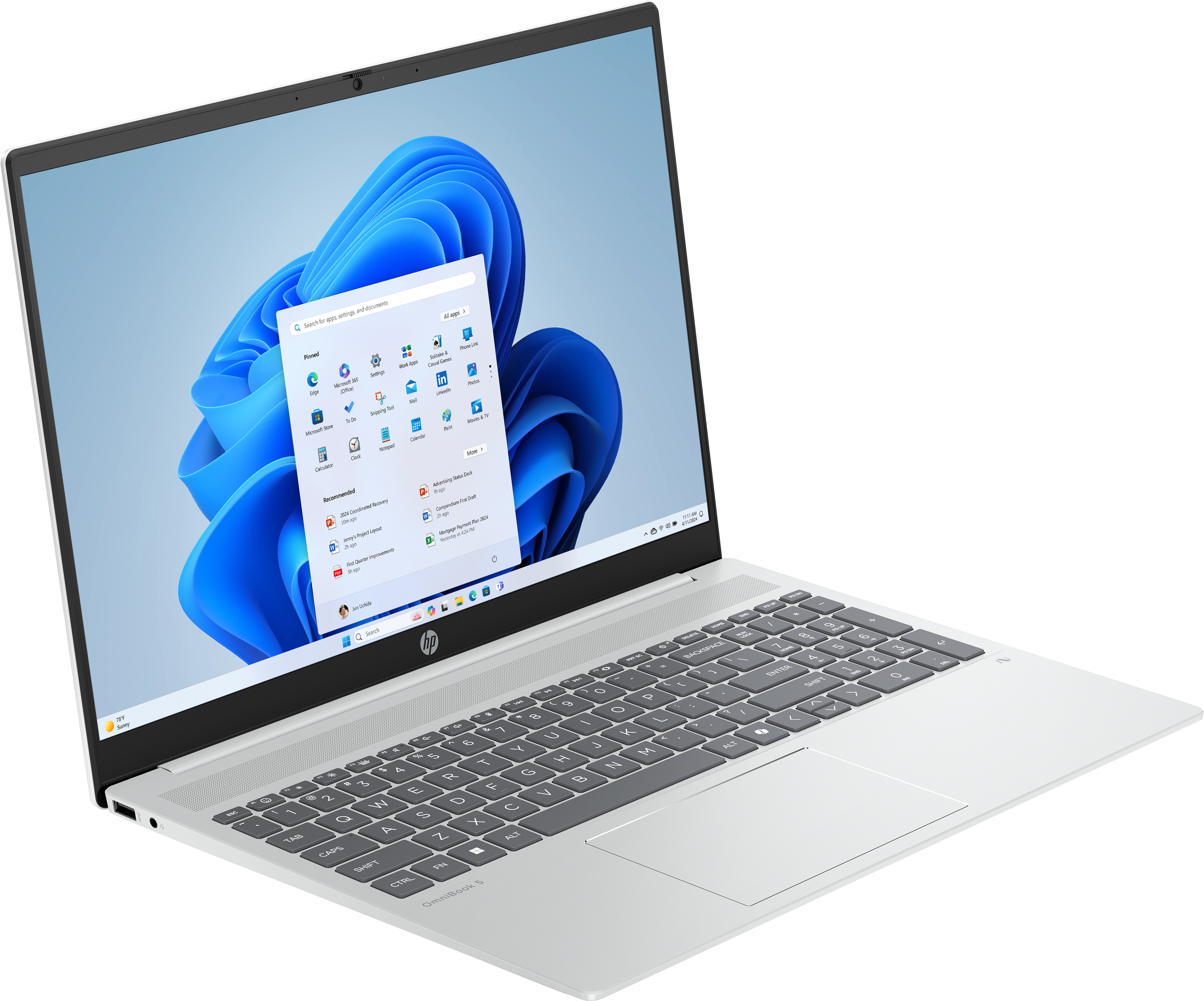 Ein silberner Laptop zeigt ein Windows 11-Menü. Tastatur und Touchpad sind sichtbar. Der Bildschirm zeigt App-Symbole.
