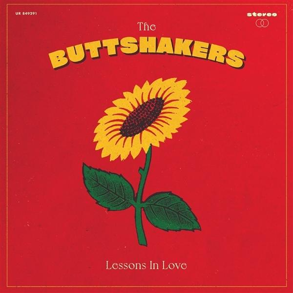 Albumcover: Eine gelbe Sonnenblume mit grünen Blättern auf rotem Grund. Der Titel 'The Buttshakers' steht über der Blume.
