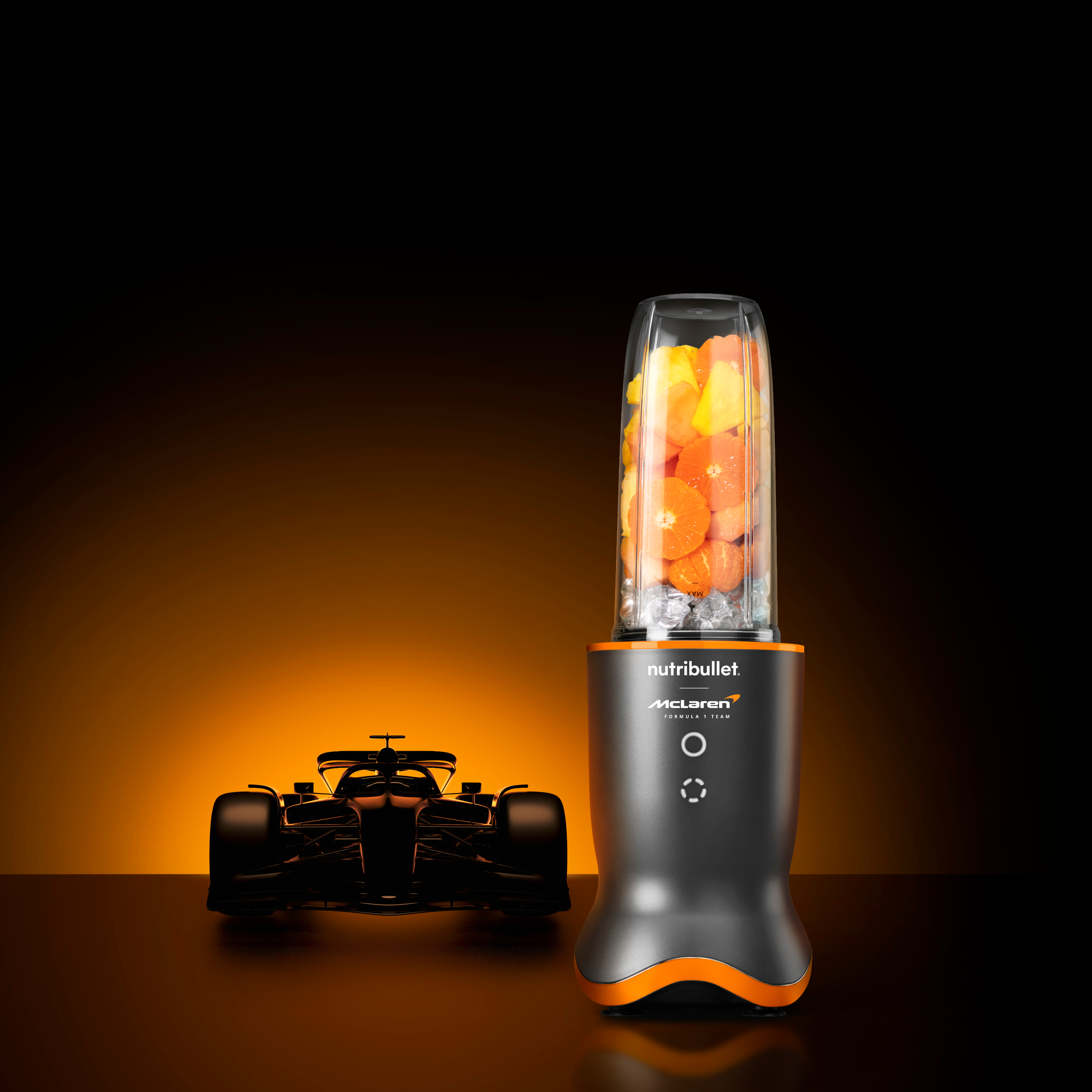 Ein Mixer mit Früchten, Eis und einem Rennwagen in einer Studioaufnahme. Der Hintergrund ist orange-schwarz.
