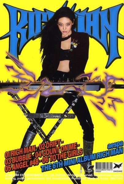 Albumcover. Eine Frau in schwarzem Outfit mit einem Instrument. Der Hintergrund ist gelb mit Text und Albumname.