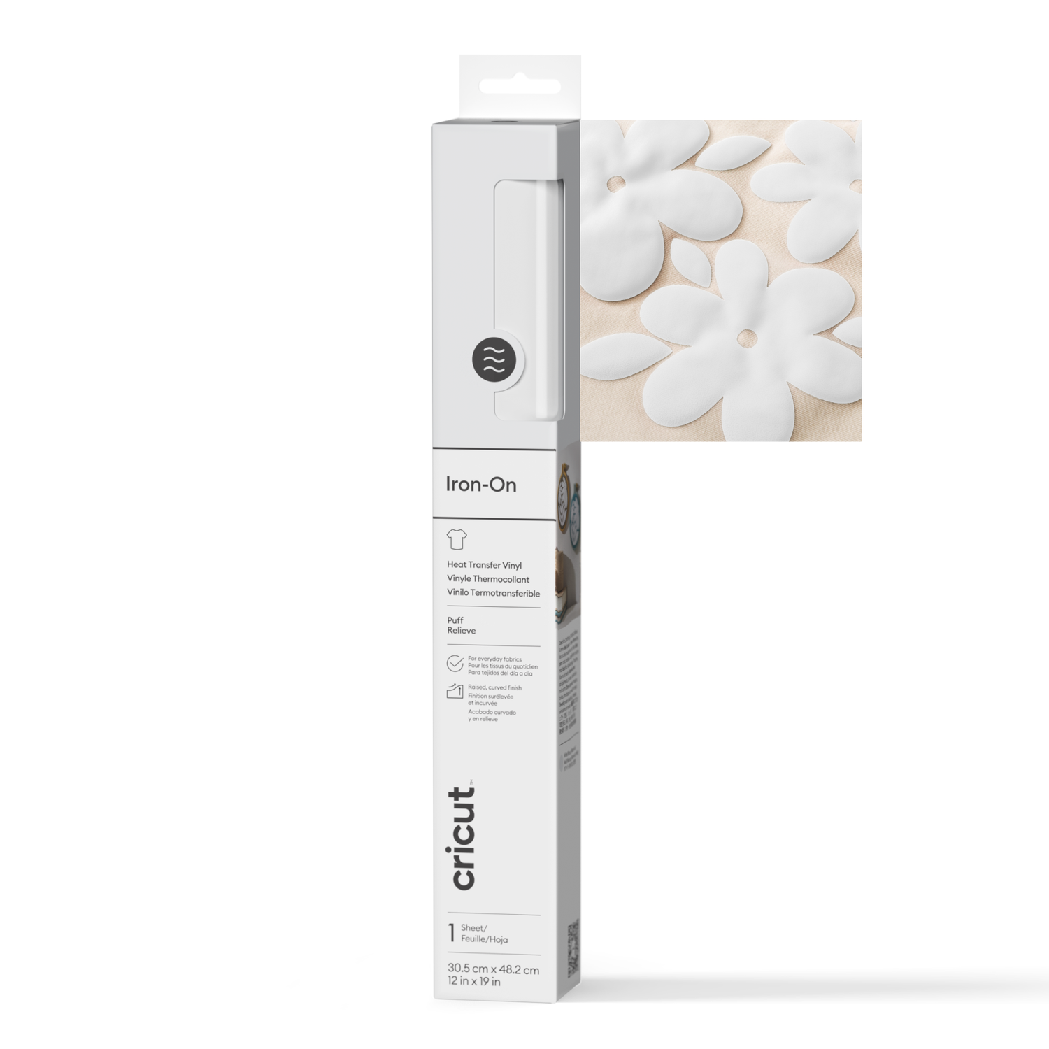 A white box with a Cricut logo, and white flower shapes on a beige surface. The box contains iron-on vinyl.