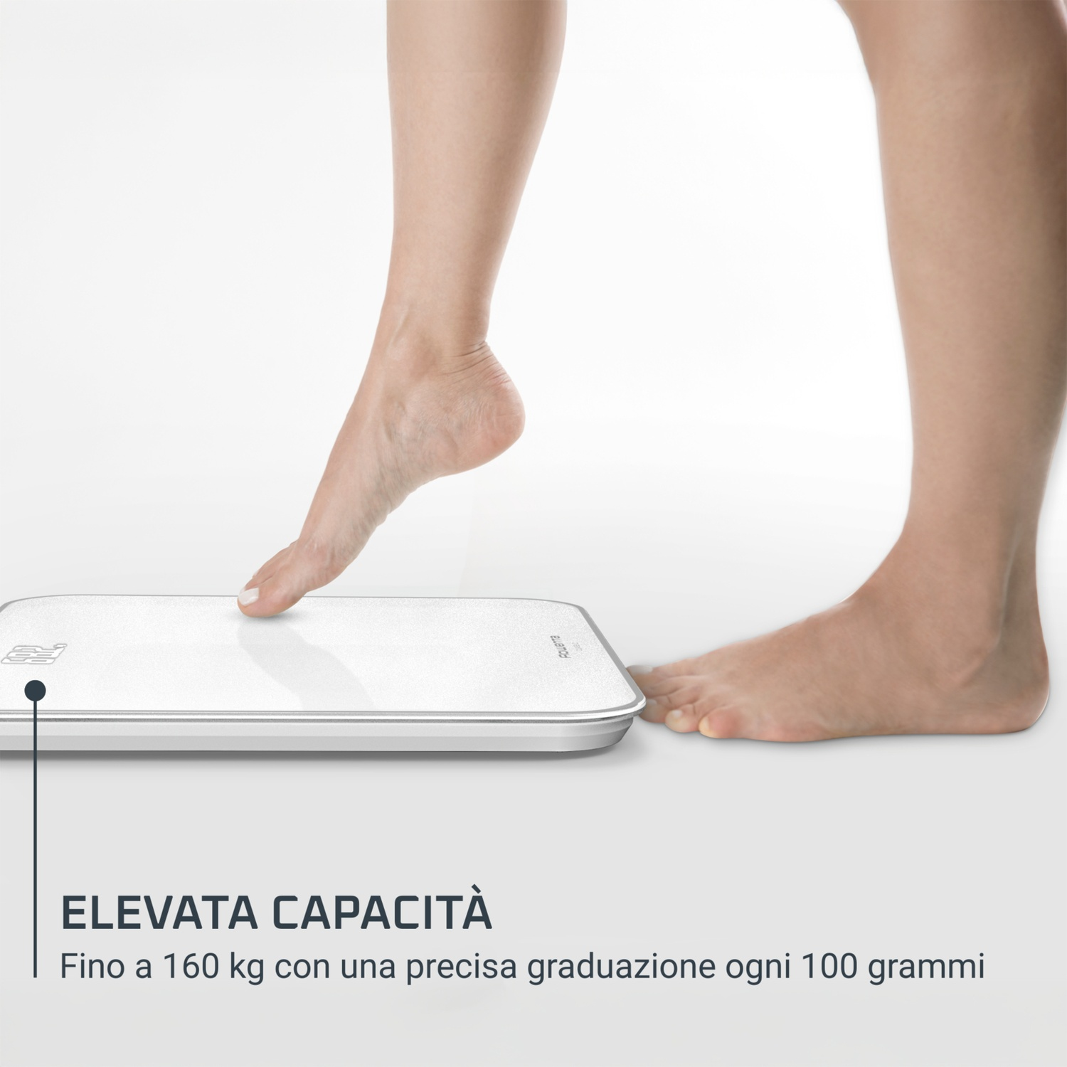 Piedi di una persona su una bilancia bianca. Un piede sale sulla bilancia, l'altro è accanto. Il testo dice 'Elevata Capacità'.