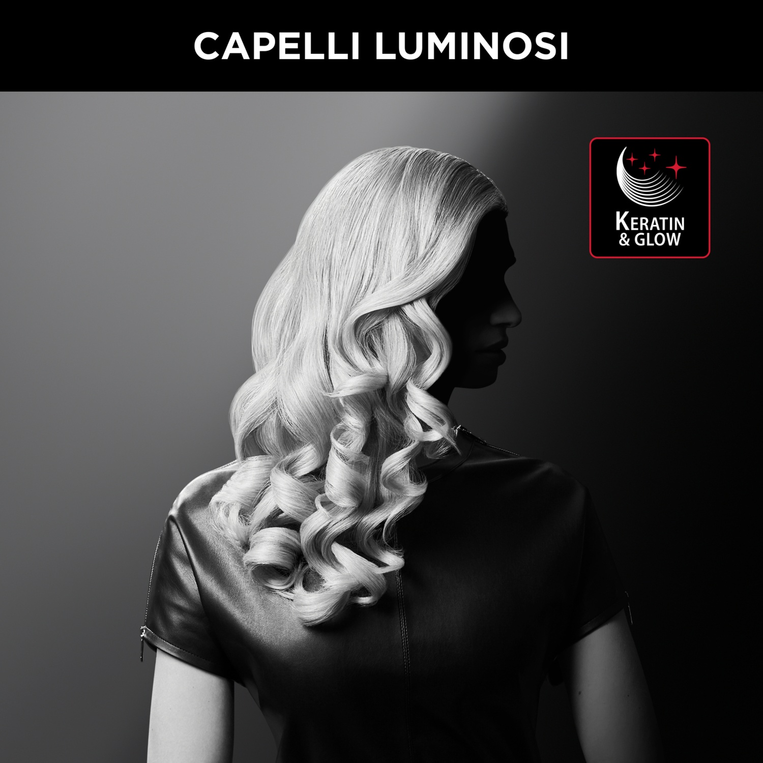 Donna con capelli biondo chiaro e mossi, indossa un vestito nero, di lato. Testo in alto: Capelli Luminosi. Logo Keratin & Glow.