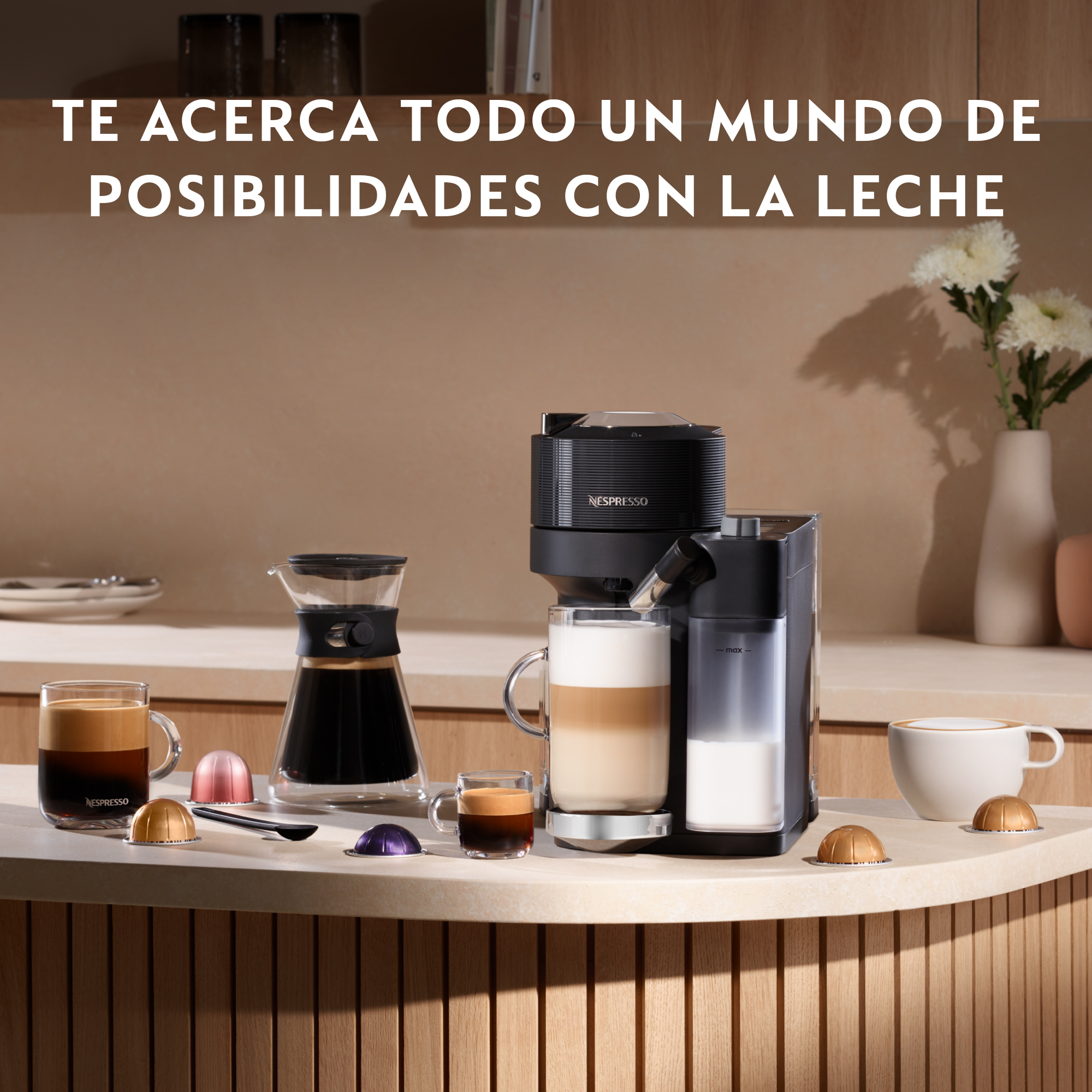 Máquina de café con latte, espresso y tazas de café en una encimera, con cápsulas. Flores en el fondo.