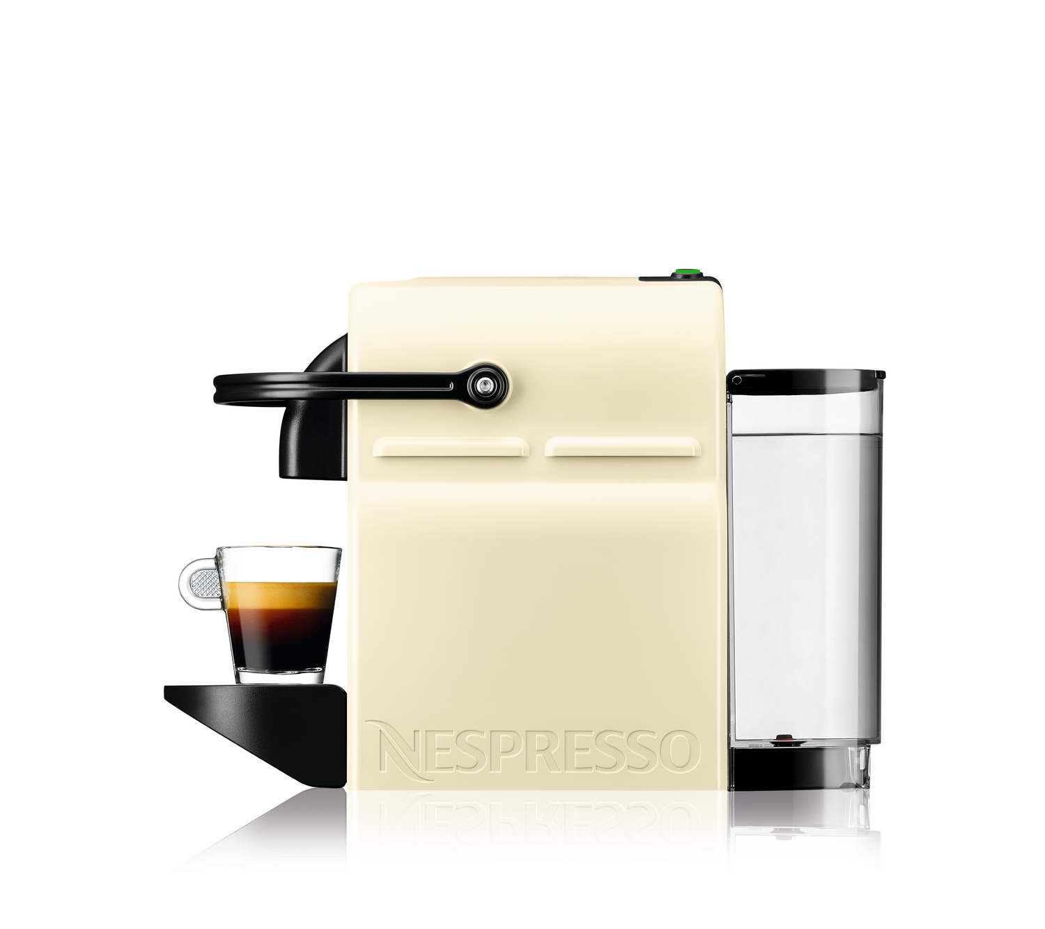Cafetera Nespresso de color crema con un vaso de espresso. Un recipiente de agua está en el lado derecho. La marca es visible.
