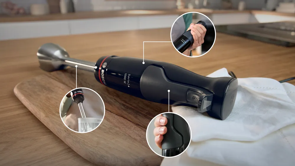 Egy fekete Bosch botmixer egy fa deszkán fekszik, a termék részleteit mutató betétekkel.