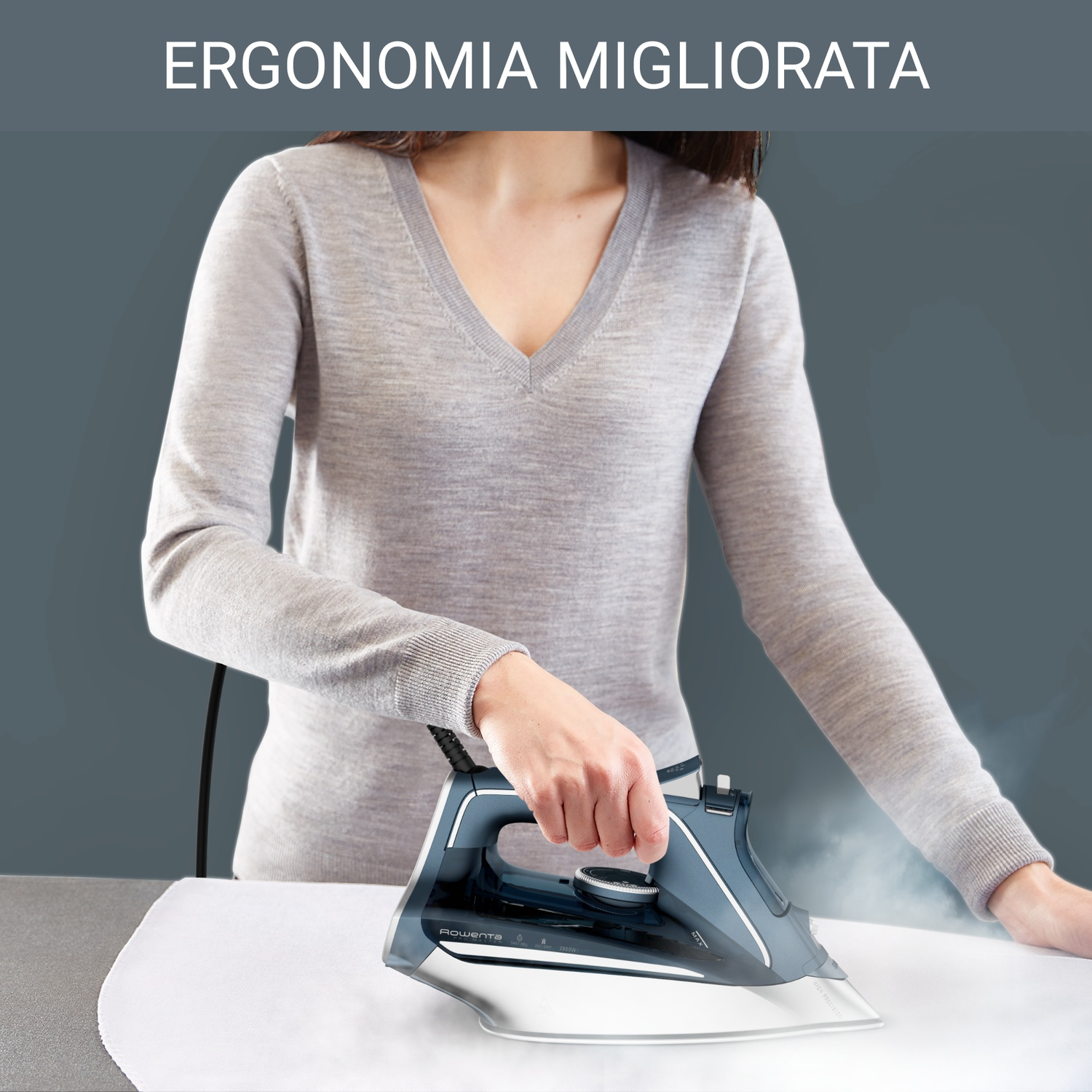 Una donna stira un tessuto bianco con un ferro grigio e blu. Il vapore sale. Sfondo grigio con testo 'ERGONOMIA MIGLIORATA'.