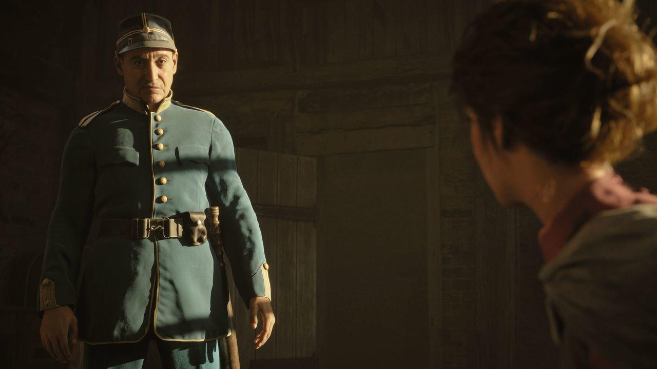 Ein Mann in blauer Uniform steht in einem dunklen Raum und blickt auf eine verschwommene Person. Die Uniform hat goldene Knöpfe und einen Gürtel.