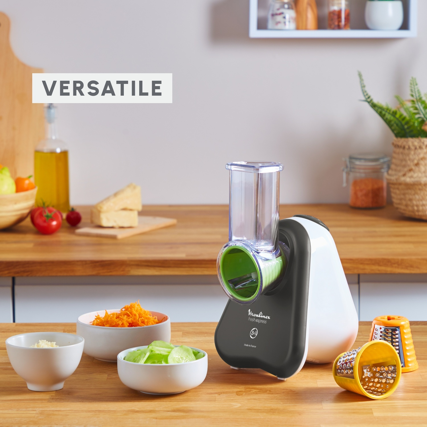 Un robot da cucina con ciotole di verdure e formaggio tritati. Un tagliere e una bottiglia d'olio sono sullo sfondo.
