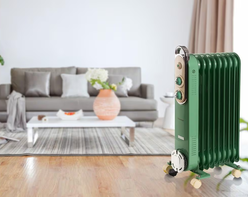 Un radiatore verde vintage in un soggiorno. Sullo sfondo un divano, un tavolino con fiori e un tappeto.