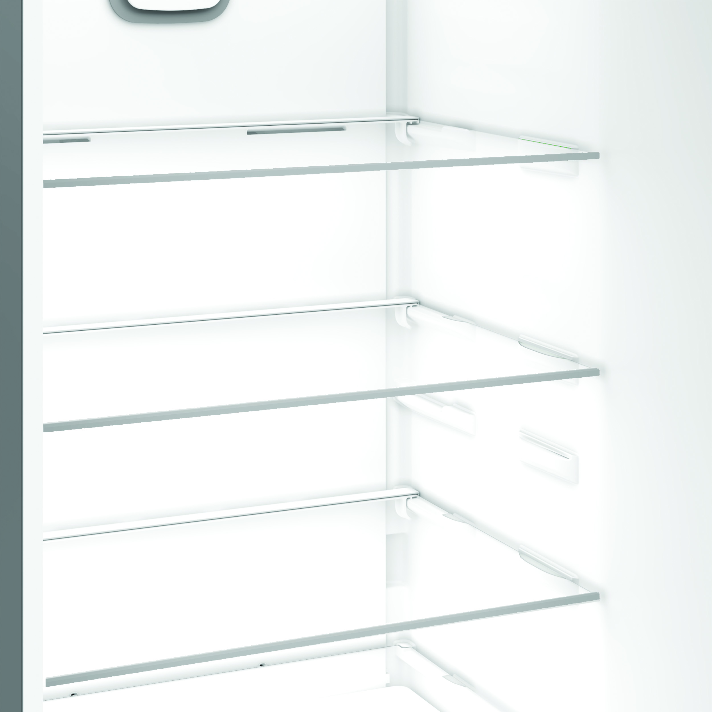 Puste białe wnętrze lodówki ze szklanymi półkami. Półki są poziome. Ściany są białe.