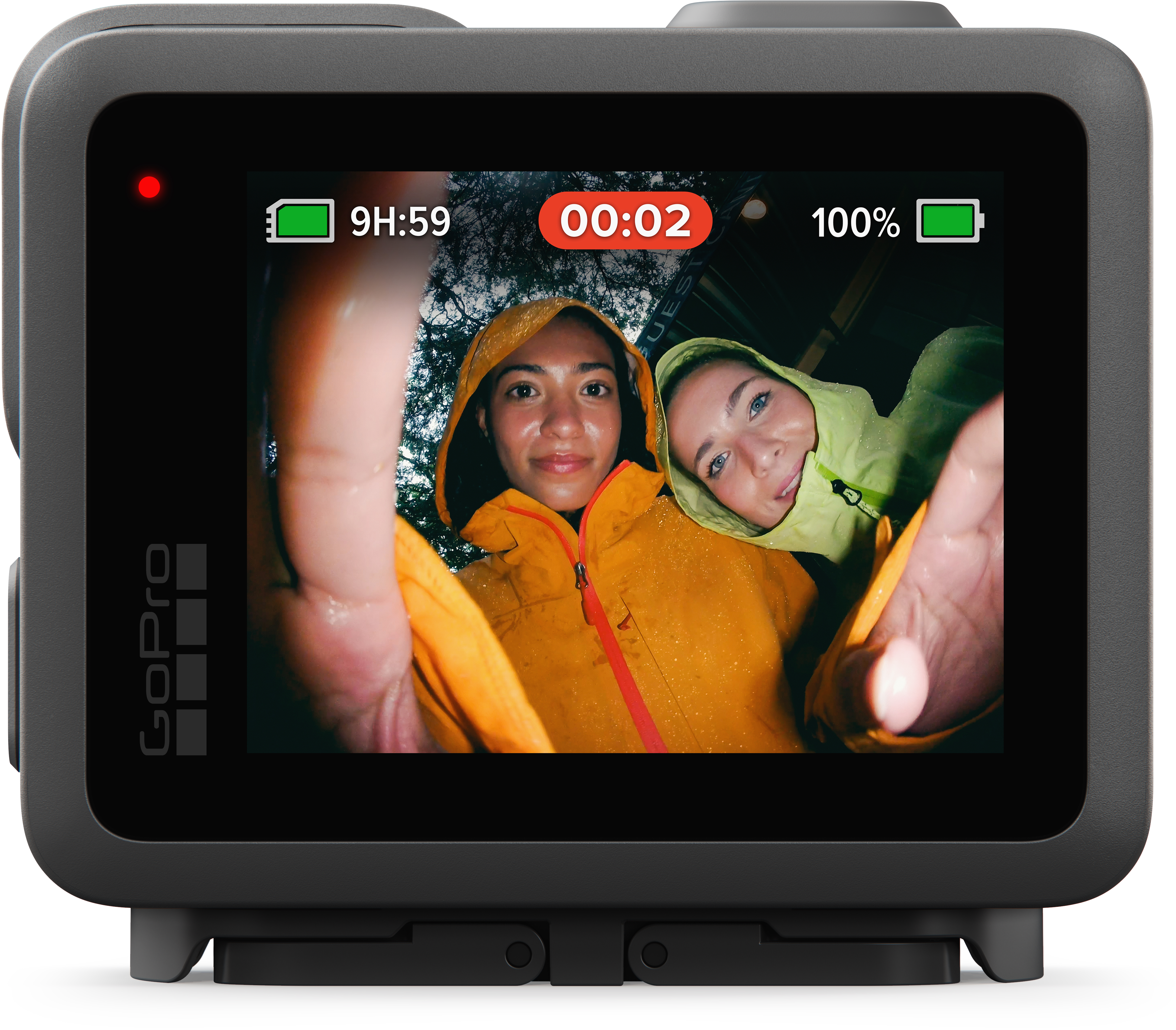Deux personnes en imperméables sourient à la caméra. L'écran GoPro affiche le temps d'enregistrement et la batterie. La caméra est noire.