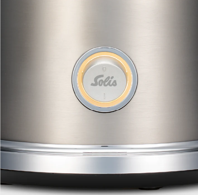 Primo piano di un elettrodomestico metallico. Al centro un pulsante circolare con il logo Solis. Sono visibili una finitura argentata e una base nera.
