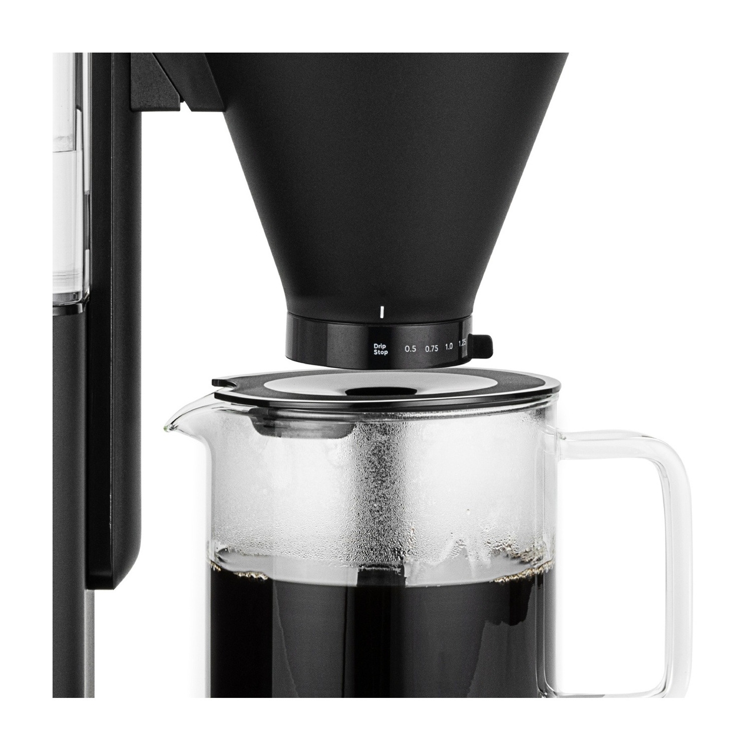 Una caffettiera nera con una caraffa in vetro piena di caffè scuro. La macchina è parzialmente visibile, mostrando il processo.
