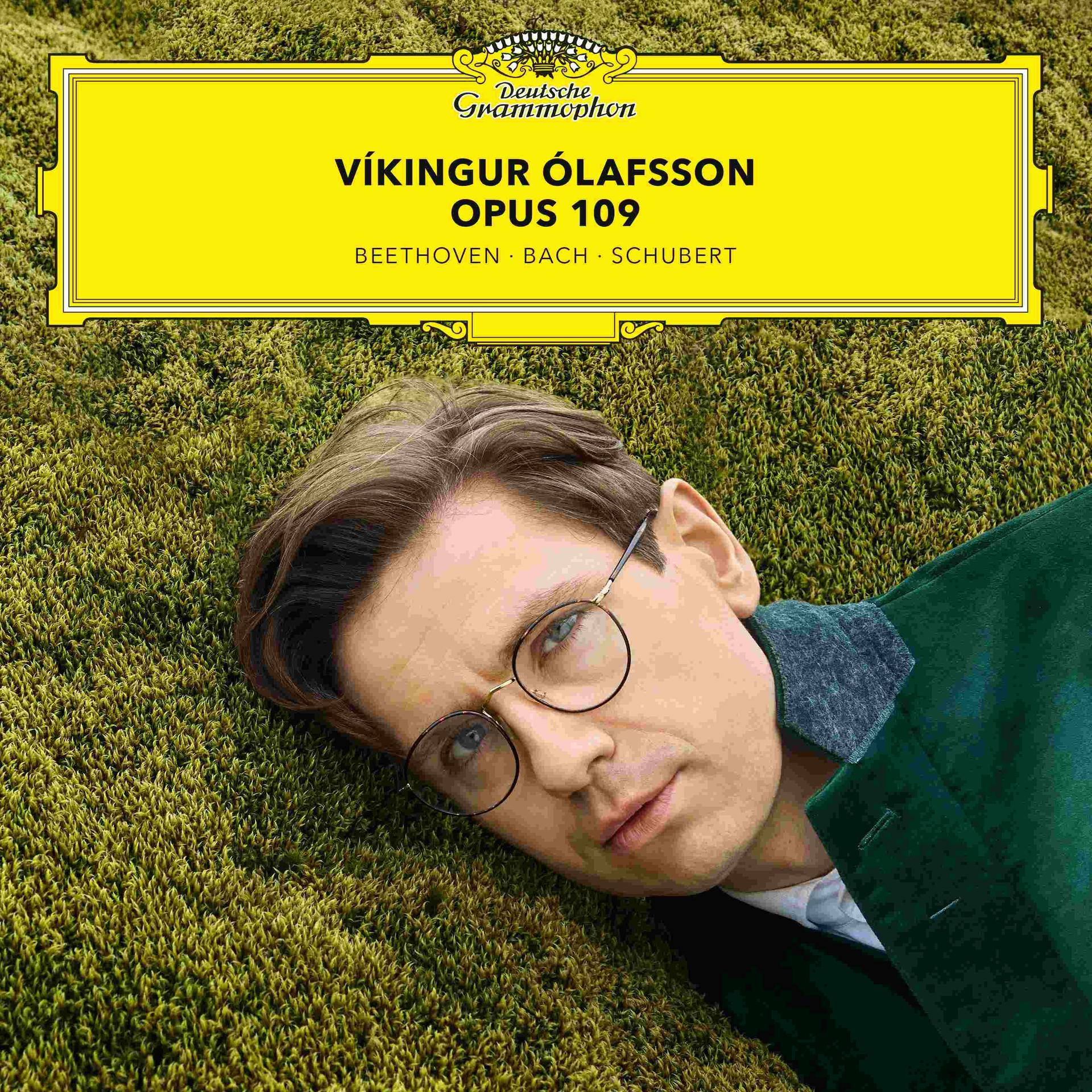 Albumcover. Porträt von Víkingur Ólafsson auf grünem Moos. Gelbe Titelleiste: Ólafsson, Opus 109, Beethoven, Bach, Schubert.