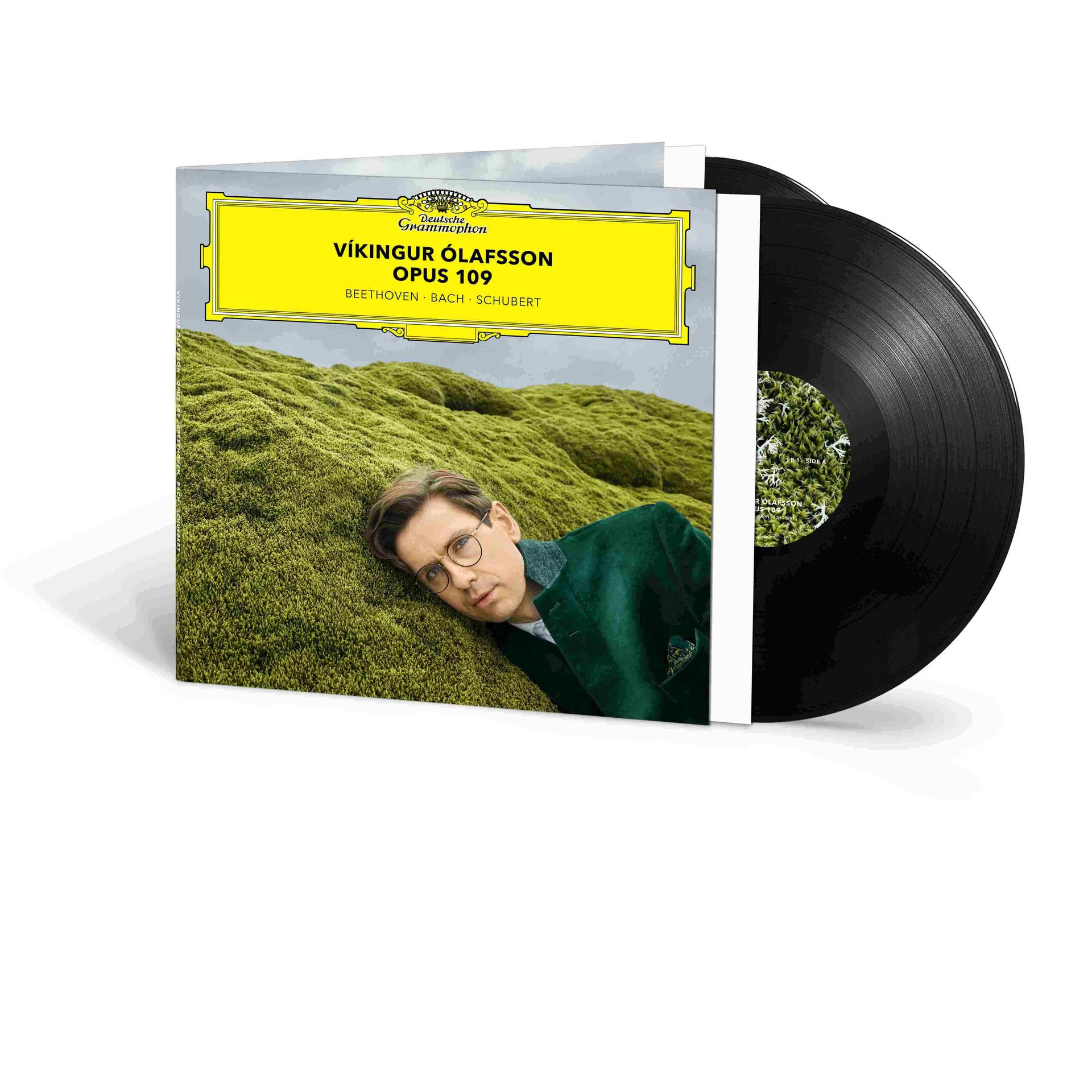 Albumcover mit Vikingur Ólafsson auf grünem Moos, neben einer Schallplatte. Text: Opus 109, Beethoven, Bach, Schubert.