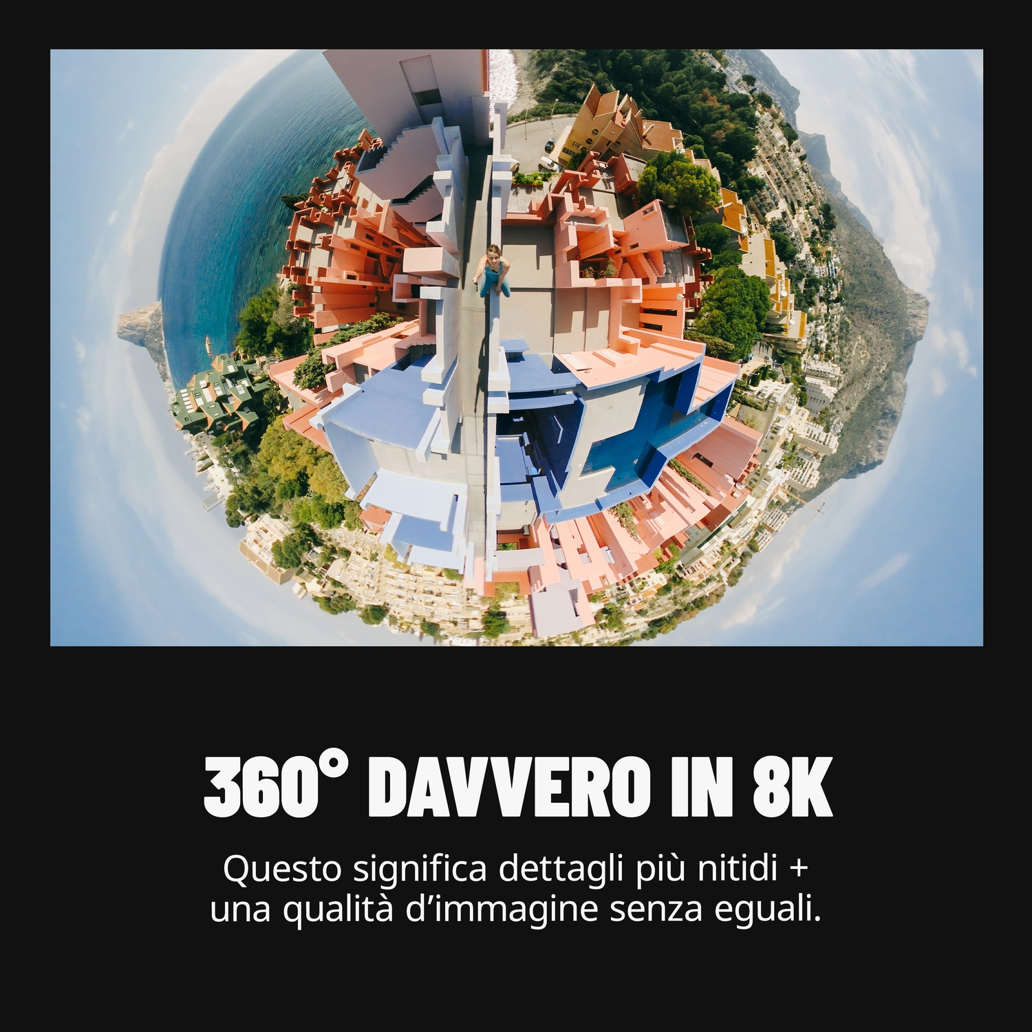 Vista panoramica: Edifici rossi, blu e bianchi, vicino al mare. Una persona è su un tetto. Cielo blu chiaro sullo sfondo.