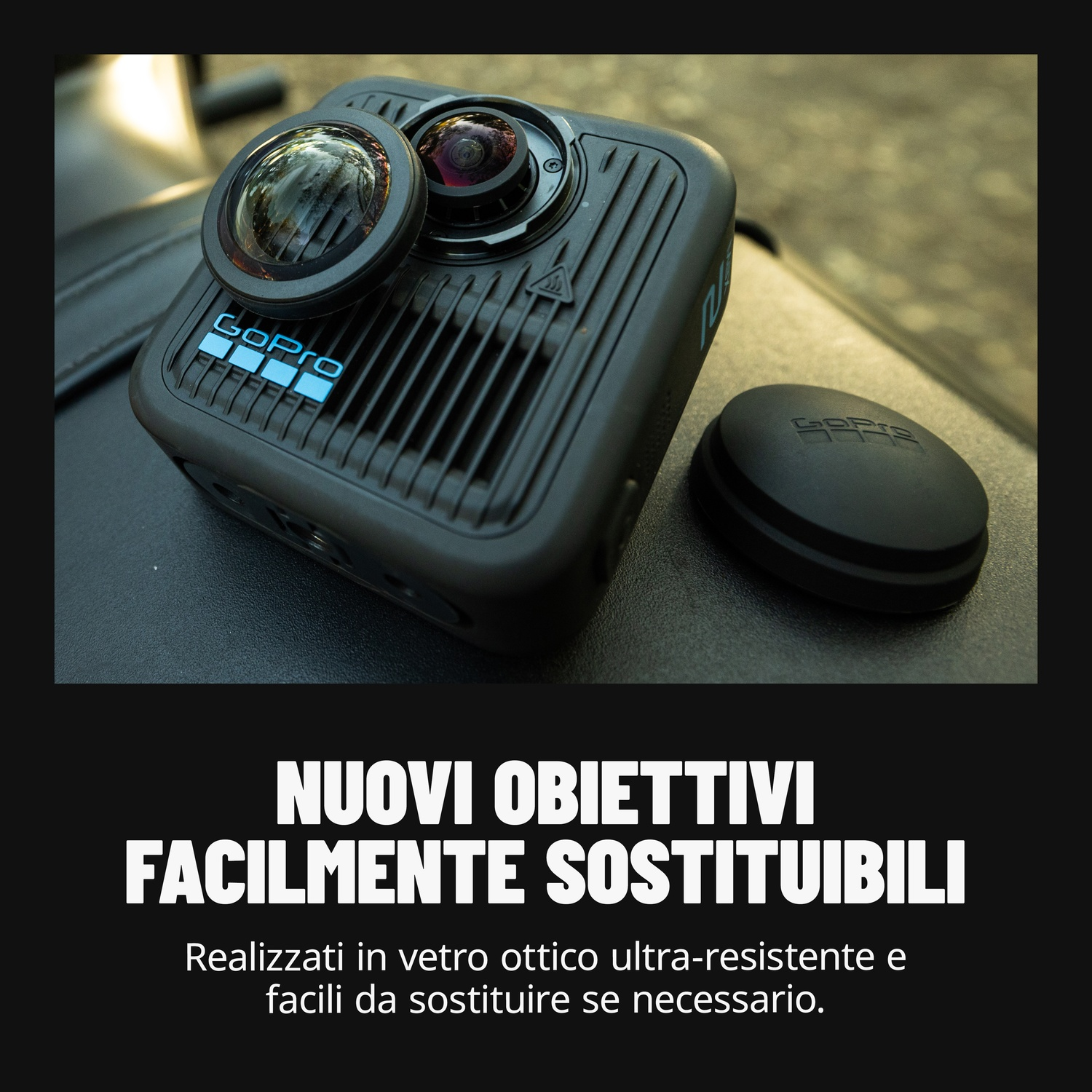 Fotocamera GoPro con due lenti, su una superficie nera, con un tappo accanto. Logo GoPro visibile. Testo sottostante: "NUOVI OBIETTIVI".