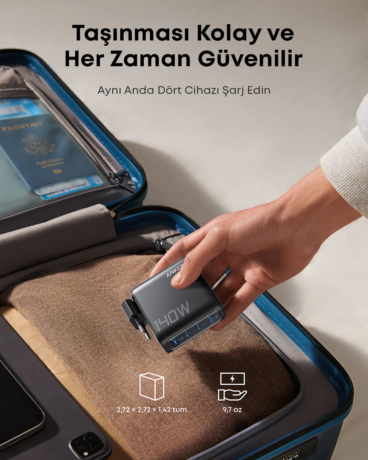 Bir el, açık bir bavulun üzerinde siyah bir Anker 140W şarj cihazı tutuyor. Bavulun içinde bir pasaport görülüyor.