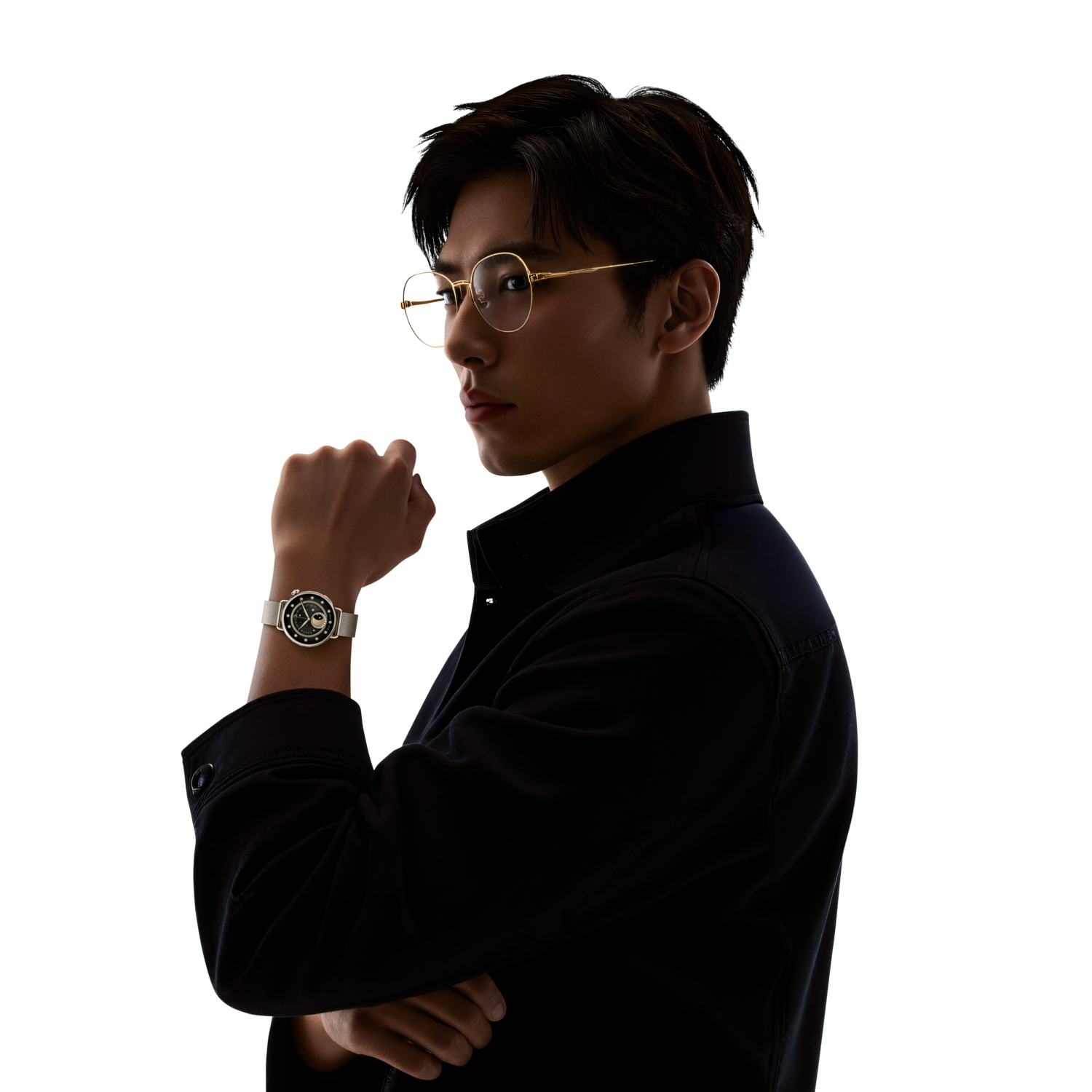 A man in glasses and a black jacket, with a watch on his wrist, looks over his shoulder.