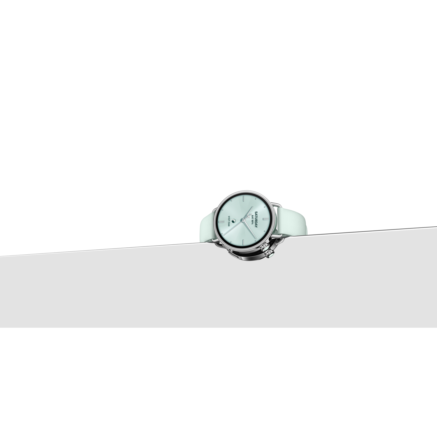 Une montre-bracelet avec un bracelet et un cadran vert clair est posée sur une surface blanche, avec un fond noir et blanc.