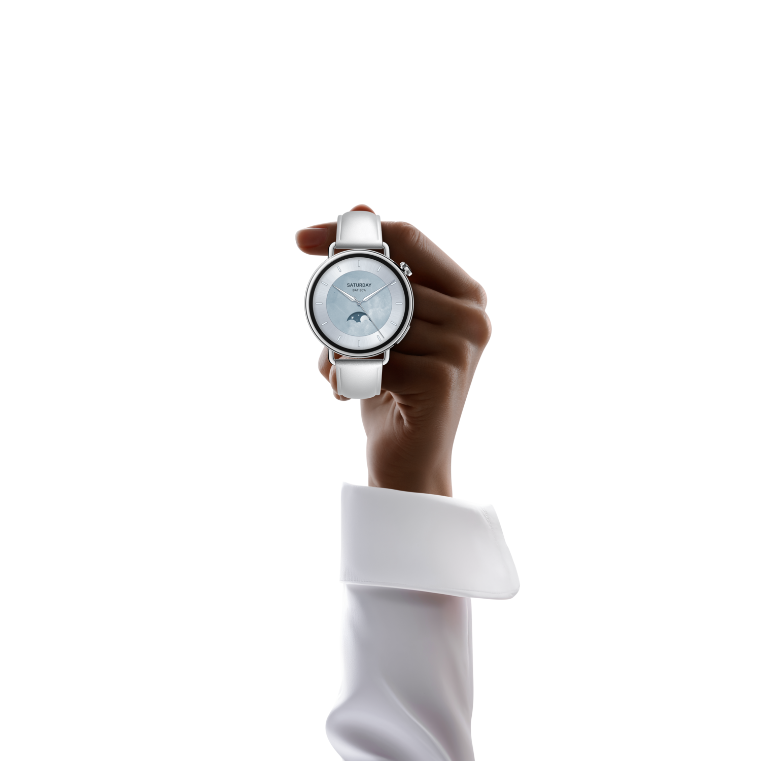 A hand holds a silver wristwatch with a white leather strap, against a black background. The watch face shows Saturday and a moon phase.