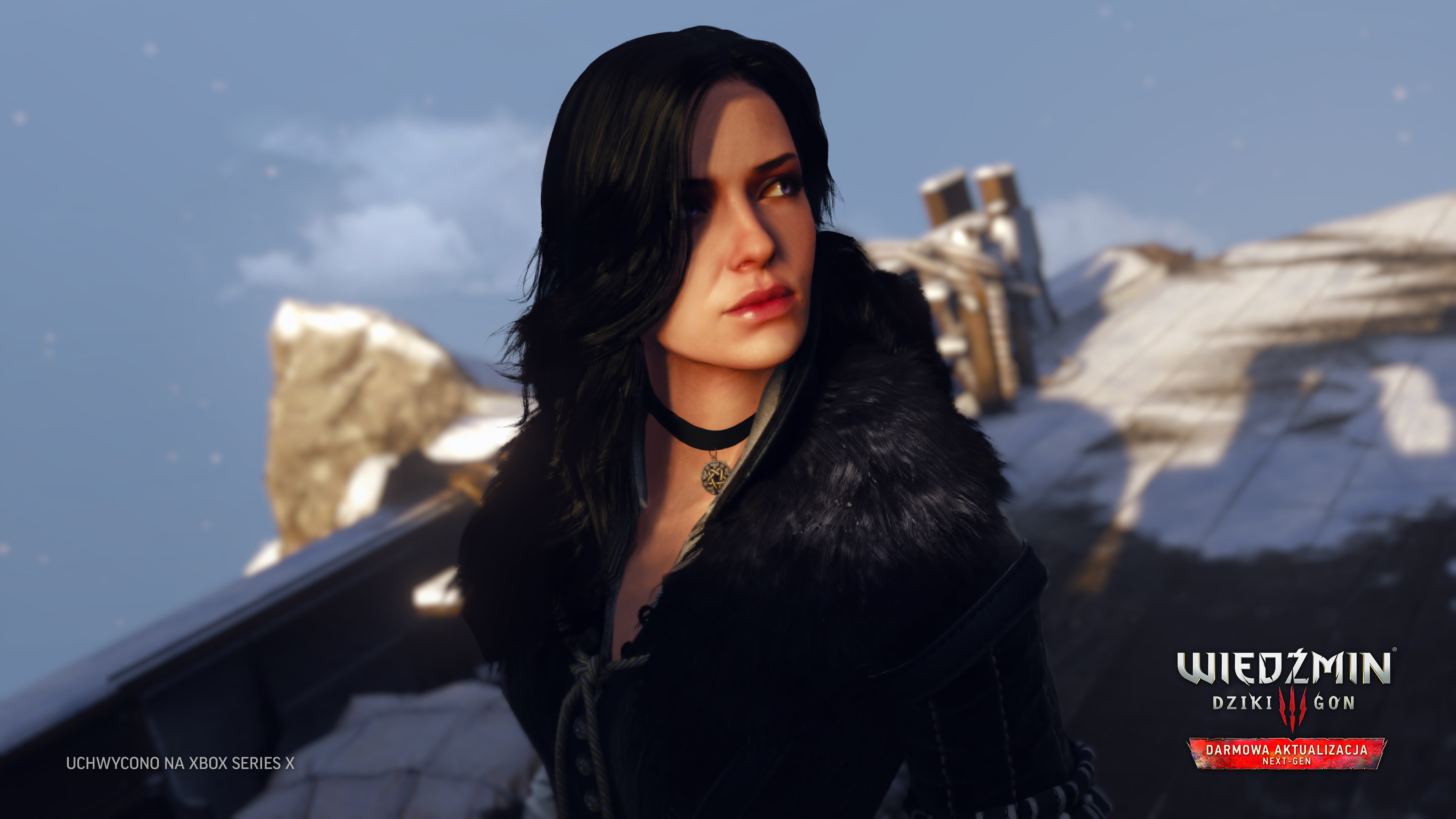 Kobieta z czarnymi włosami w czarnym stroju. Tło przedstawia zaśnieżony krajobraz i logo gry.