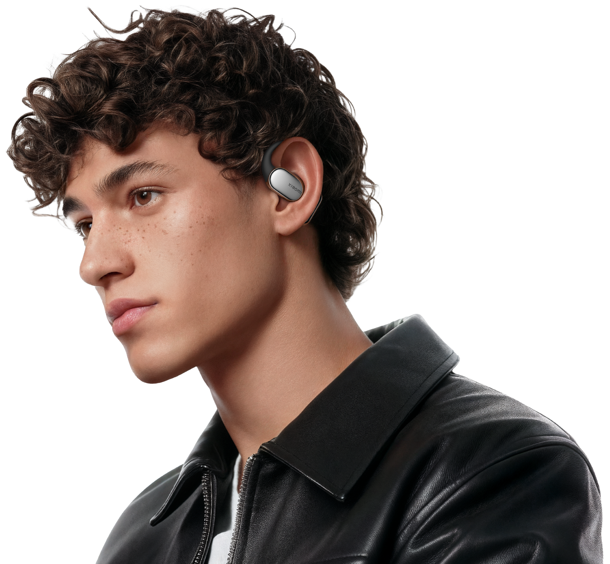 Młody mężczyzna z wkładką douszną w prawym uchu, w czarnej skórzanej kurtce i kręconymi włosami.
