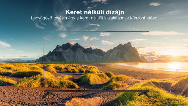 Egy TV egy hegyes tengerparti jelenettel a képernyőn belül. A keret keret nélküli kialakítású, bemutatva a képet.