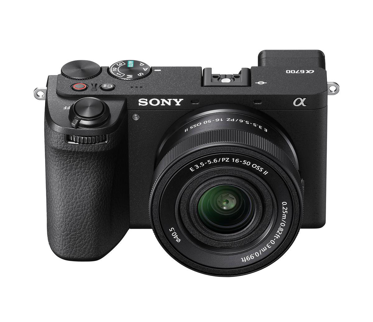 Eine schwarze Sony Alpha Kamera mit Objektiv, Knöpfen und Einstellrädern. Das Objektiv hat Text und Zahlen. Die Kamera steht auf weißem Untergrund.