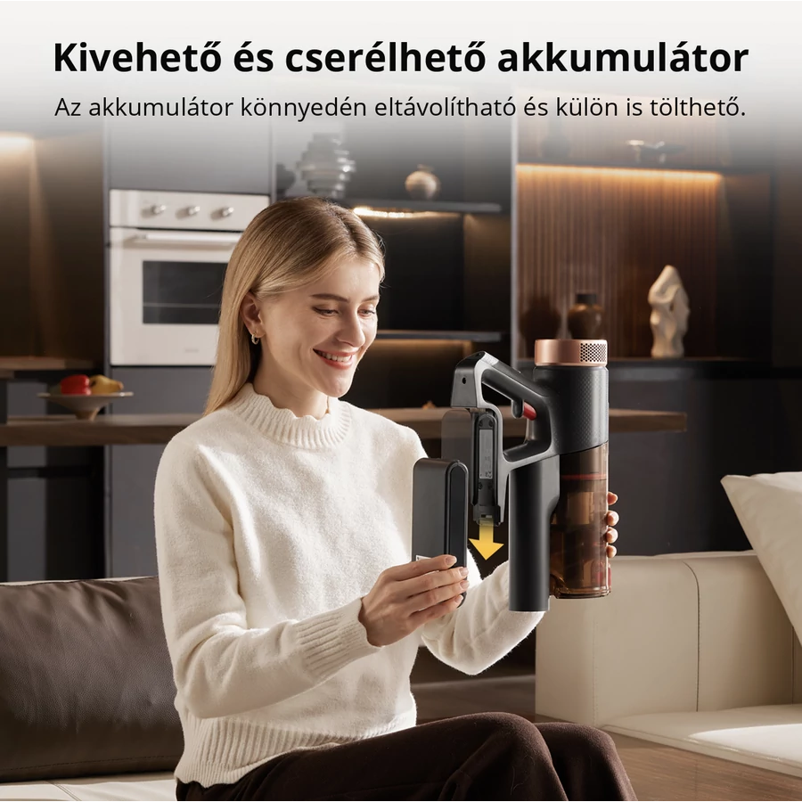 Egy fehér pulóveres nő kivesz egy fekete akkumulátort egy porszívóból. A porszívó fekete és barna. A háttér egy konyha.