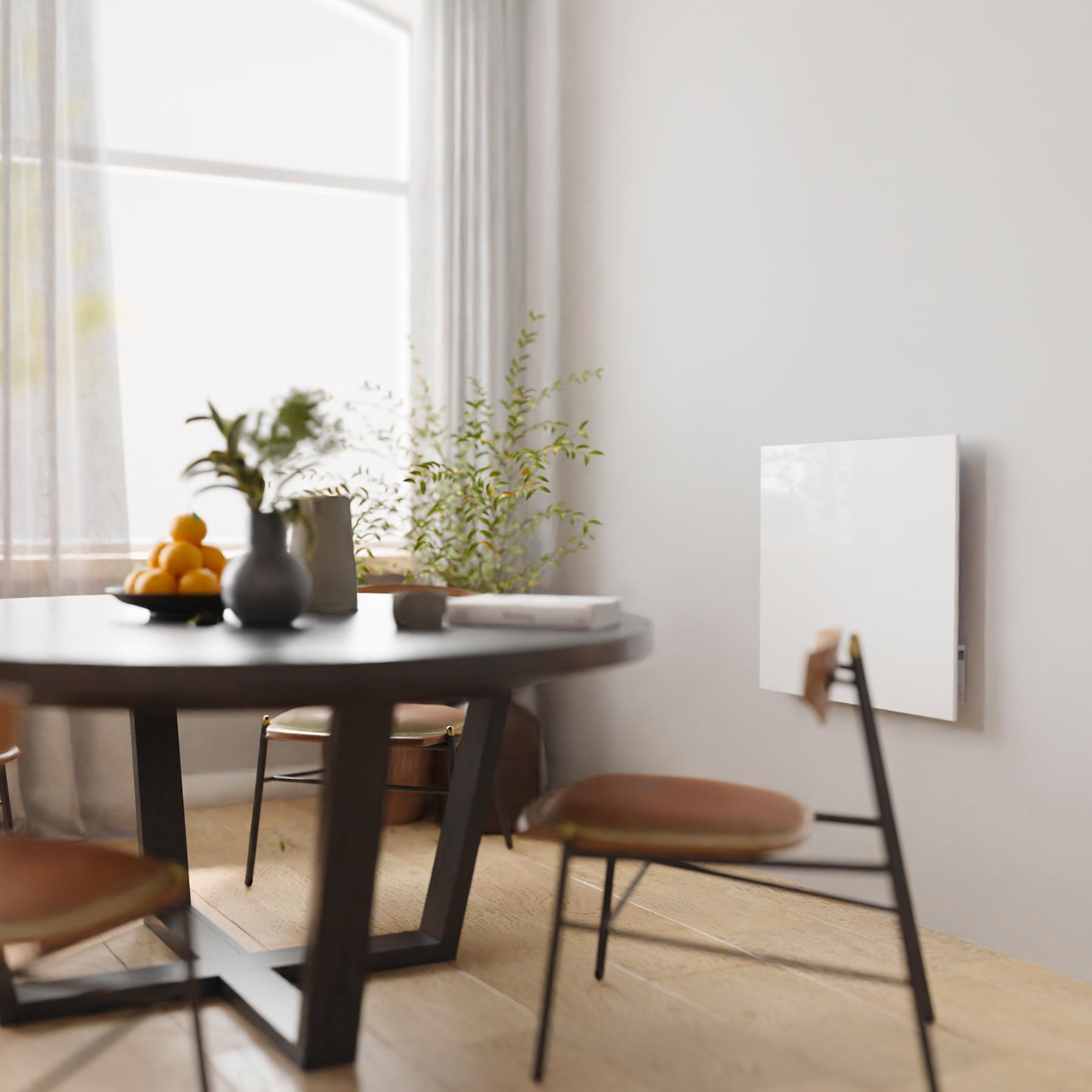 Ein Esszimmer mit rundem Tisch, Vase und Orangen. An der Wand befindet sich eine weiße Tafel. Fenster und Stühle vervollständigen die Szene.