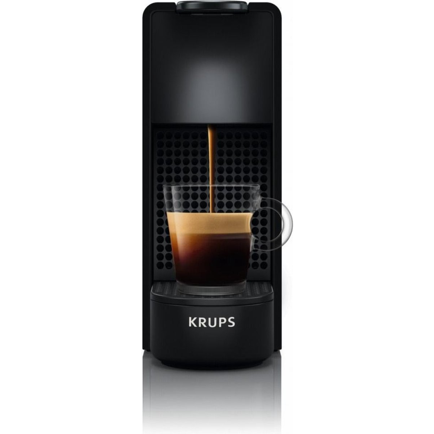 A black Krups espresso machine is dispensing coffee into a clear glass. The glass is on the machine's base. White background.