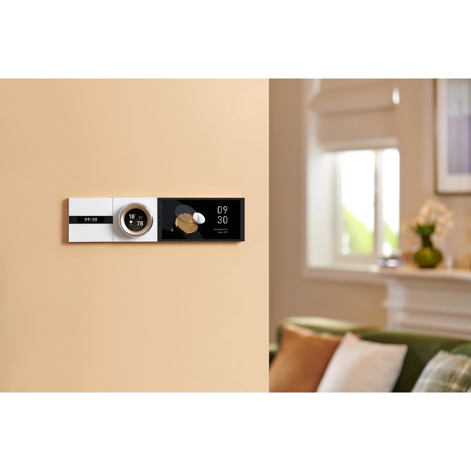 A smart home control panel is mounted on a beige wall. It displays time, temperature, and other information. A living room is in the background.