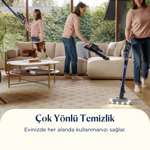 Bir kadın oturma odasını süpürüyor. Köpek kanepede yatıyor. Başka bir kadın süpürge tutuyor.