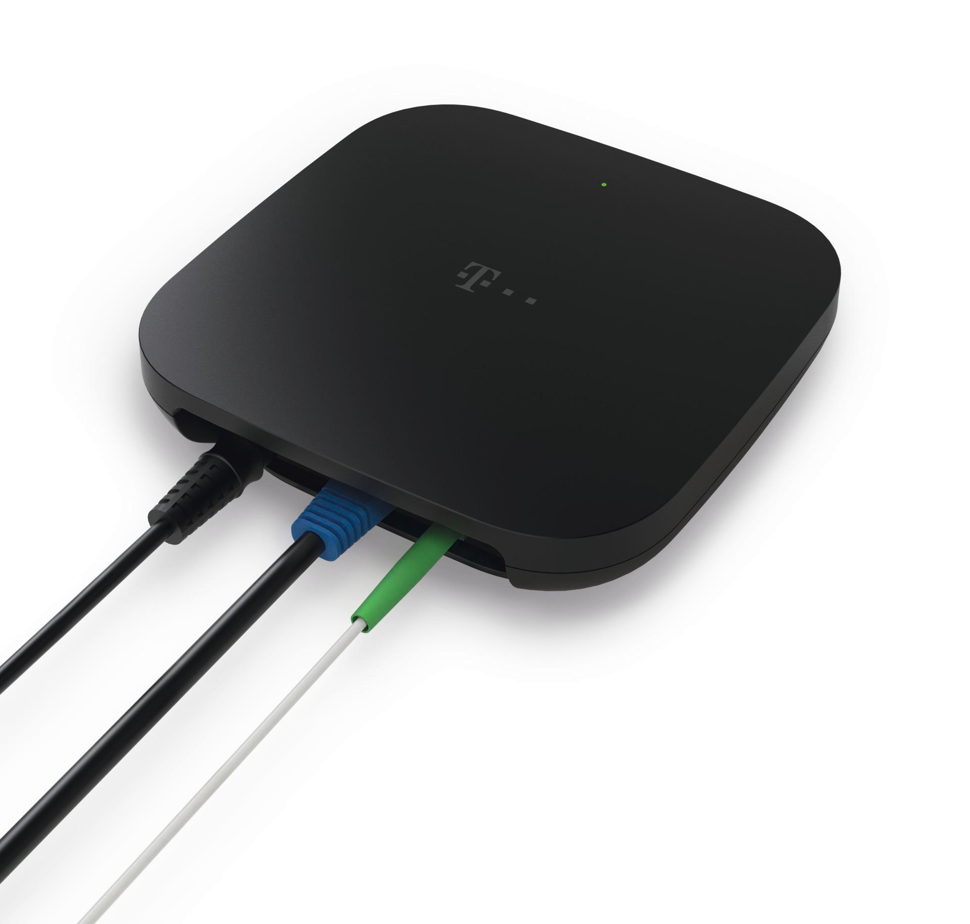 Schwarzes T-Mobile-Gerät mit Kabeln. Blaue, grüne, schwarze und weiße Kabel sind an das Gerät angeschlossen. Weißer Hintergrund.