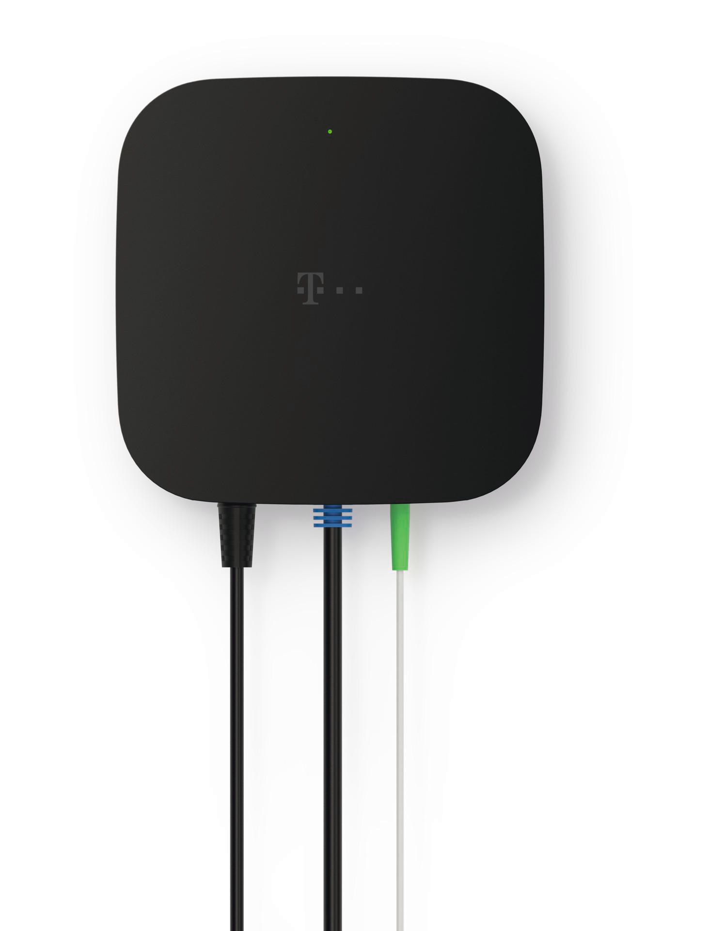 Ein schwarzes quadratisches Gerät mit T-Mobile-Logo. Unten sind drei Kabel in Schwarz, Blau-Weiß und Grün-Weiß angeschlossen.