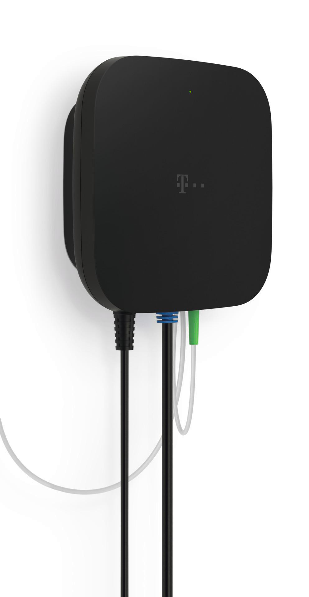 Ein schwarzes Gerät mit T-Mobile-Logo. Kabel in verschiedenen Farben sind angeschlossen. Ein grünes Licht leuchtet.