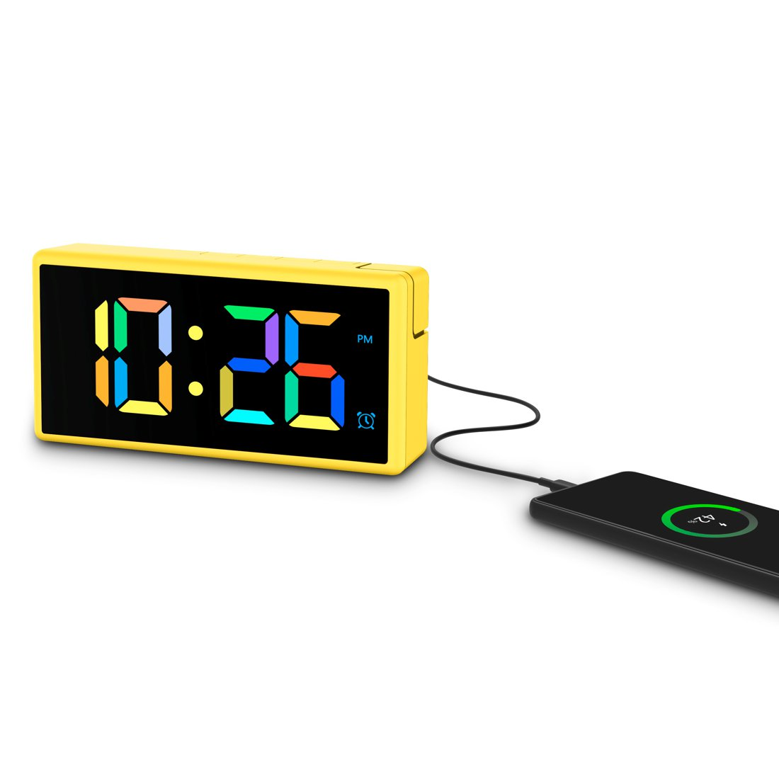 Żółty zegar cyfrowy pokazuje 10:26 PM, podłączony do ładującego się telefonu. Zegar ma czarny ekran z kolorowymi cyframi.